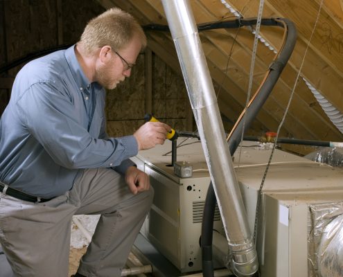 Service Man Inspects Furnace